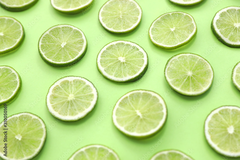 Slices of fresh juicy limes on green background Slices of fresh juicy limes on green background