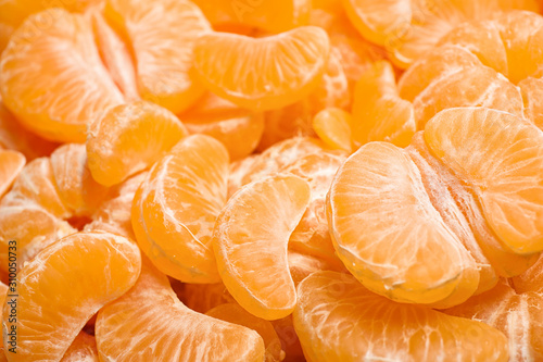 Peeled fresh ripe tangerines as background, closeup