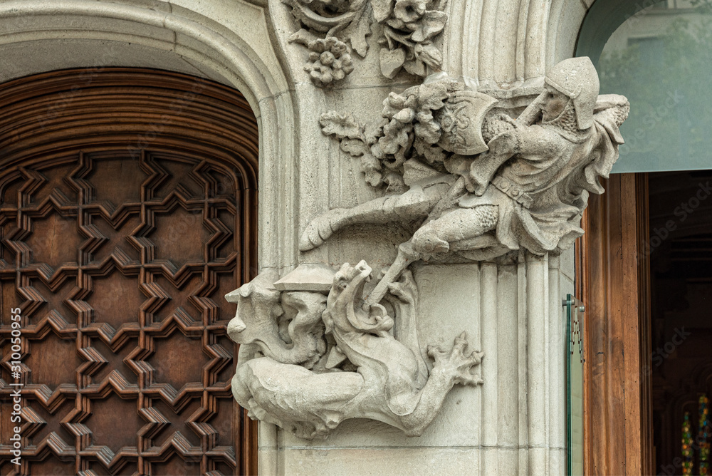 Saint George and the dragon detail in facade  Representation in low relief of St. George and the dragon in a column at the entrance of a building in Barcelona, Spain