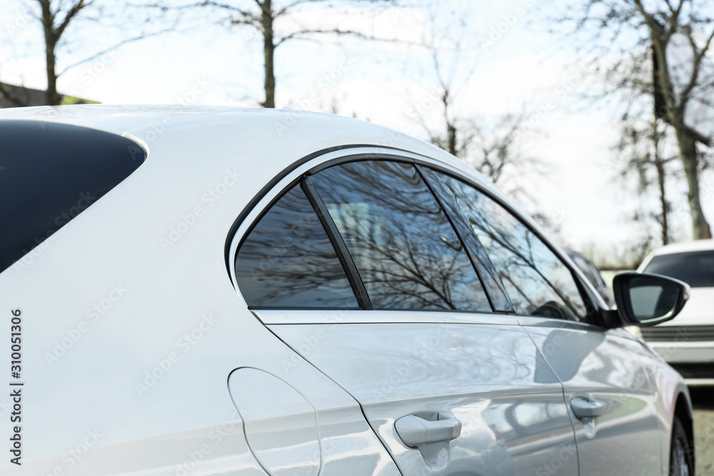 Modern car with tinting foil on window outdoors, closeup Modern car with tinting foil on window outdoors, closeup