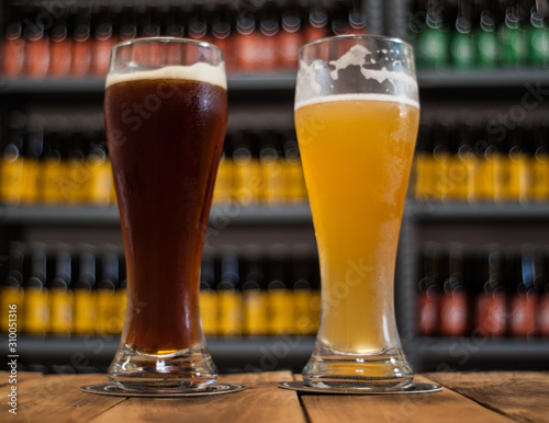 Close-up of two beer glasses on a wood table