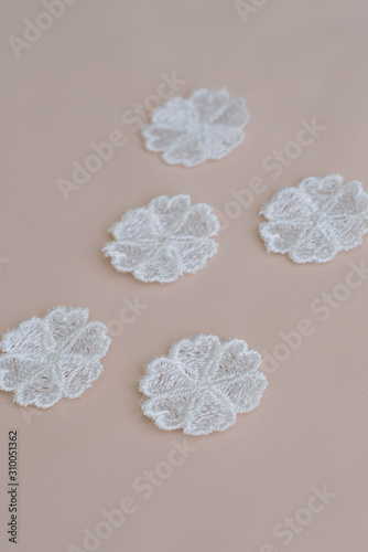 Texture lace fabric. lace on white background studio. thin fabric made of yarn or thread. a background image of ivory-colored lace flowers. White lace on beige background.
