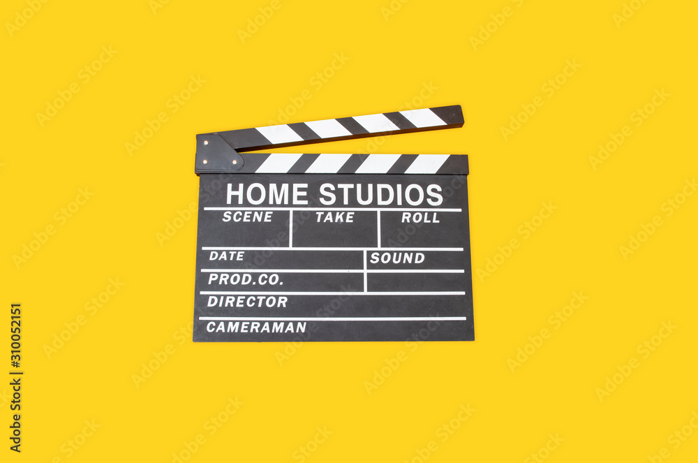 Opened movie film clap board on yellow background, film making device