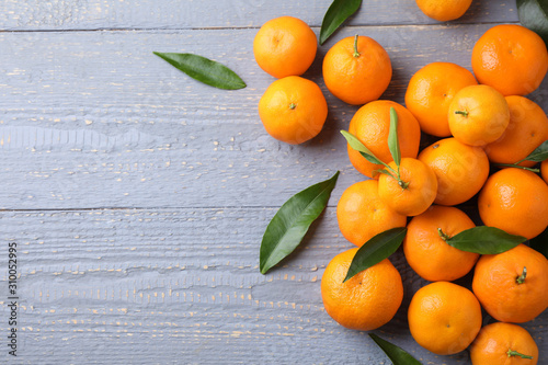 Fresh ripe tangerines on grey wooden table, flat lay. Space for text