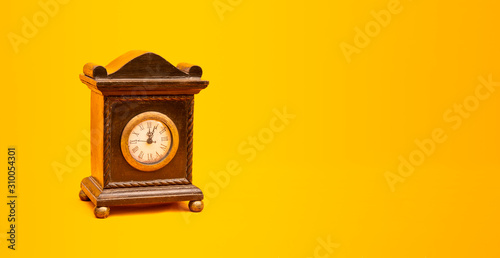 Vintage style alarm clock on yellow background banner with copy space