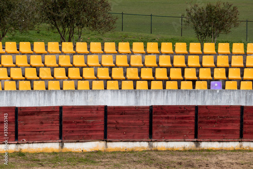 Circular old seated spectator stand with yellow benches. Derelict. Grunge.