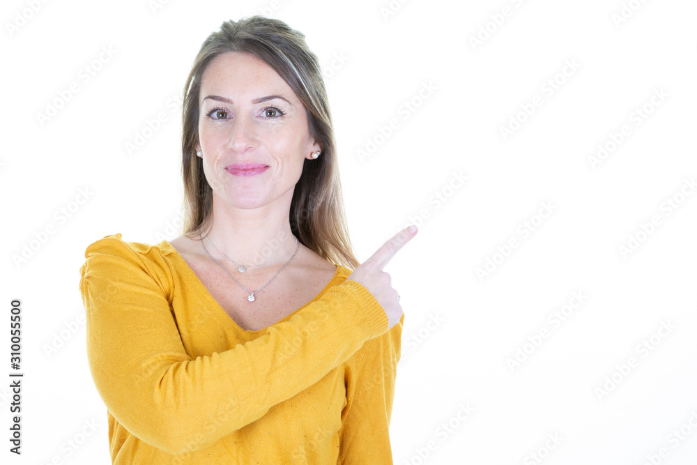 young woman pointing aside finger at copyspace looks in camera young woman pointing aside finger at copyspace looks in camera
