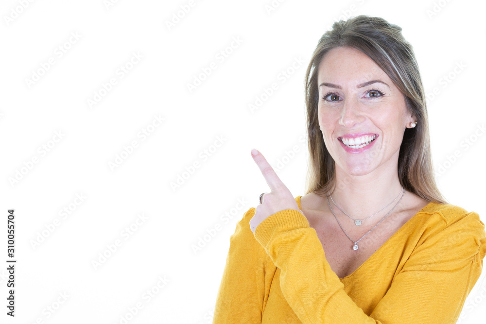 Smiling girl shows finger aside up Indicate free copy space woman dressed in knitted warm yellow sweater isolated white background Smiling girl shows finger aside up Indicate free copy space woman dressed in knitted warm yellow sweater isolated white background