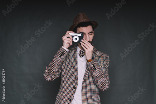 Bearded hipster taking picture with photo camera