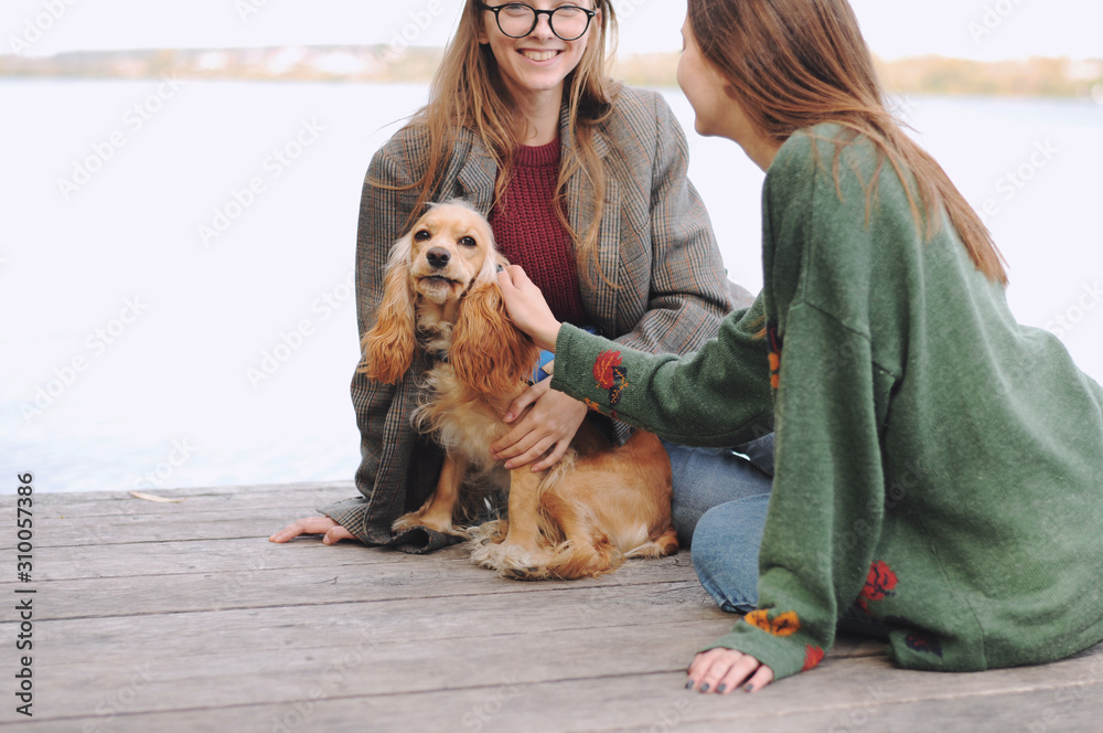 Two girls and english cocker spaniel dog lying on wooden bridge.Portrait of dog outside (outdoors). Sunny day. Two girls and english cocker spaniel dog lying on wooden bridge.Portrait of dog outside (outdoors). Sunny day.