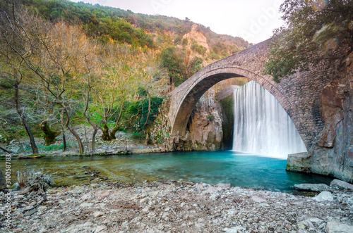 Paleokarya, old, stone, arched bridge, between two waterfalls. Trikala prefecture, Thessaly, Greece