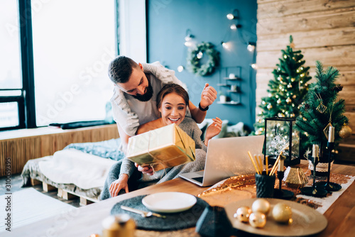 Couple exchanging Christmas presents at home