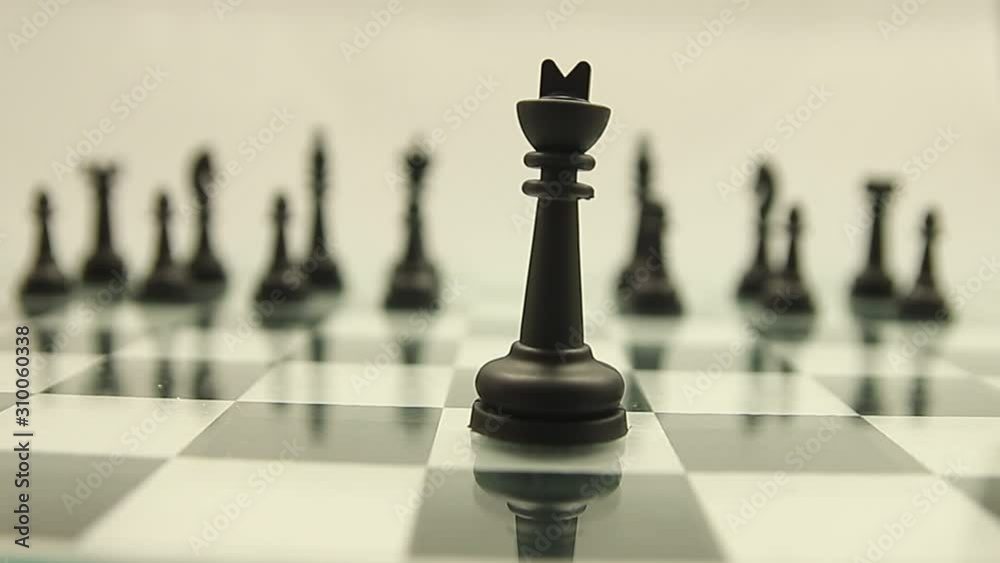 Black king on a chessboard against the background of the rest of the black pieces on a white background. Black king on a chessboard against the background of the rest of the black pieces on a white background.