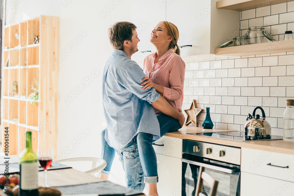 Cheerful couple embracing in kitchen Cheerful couple embracing in kitchen