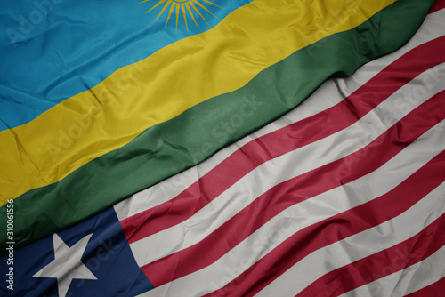 waving colorful flag of liberia and national flag of rwanda.