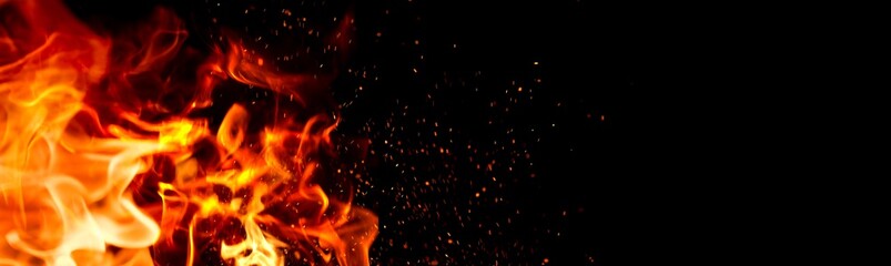 Fire Flame on black background. Flame border close up. Sparks from bonfire over dark night background. Christmas backdrop, wide screen