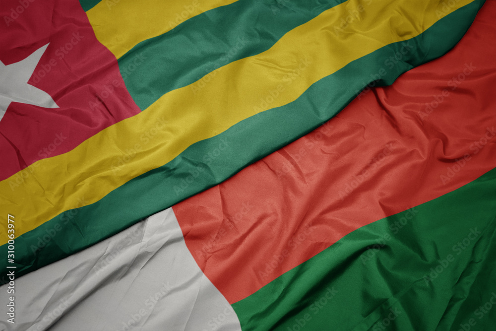 waving colorful flag of madagascar and national flag of togo.