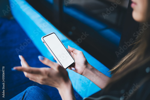 Faceless young woman using smartphone