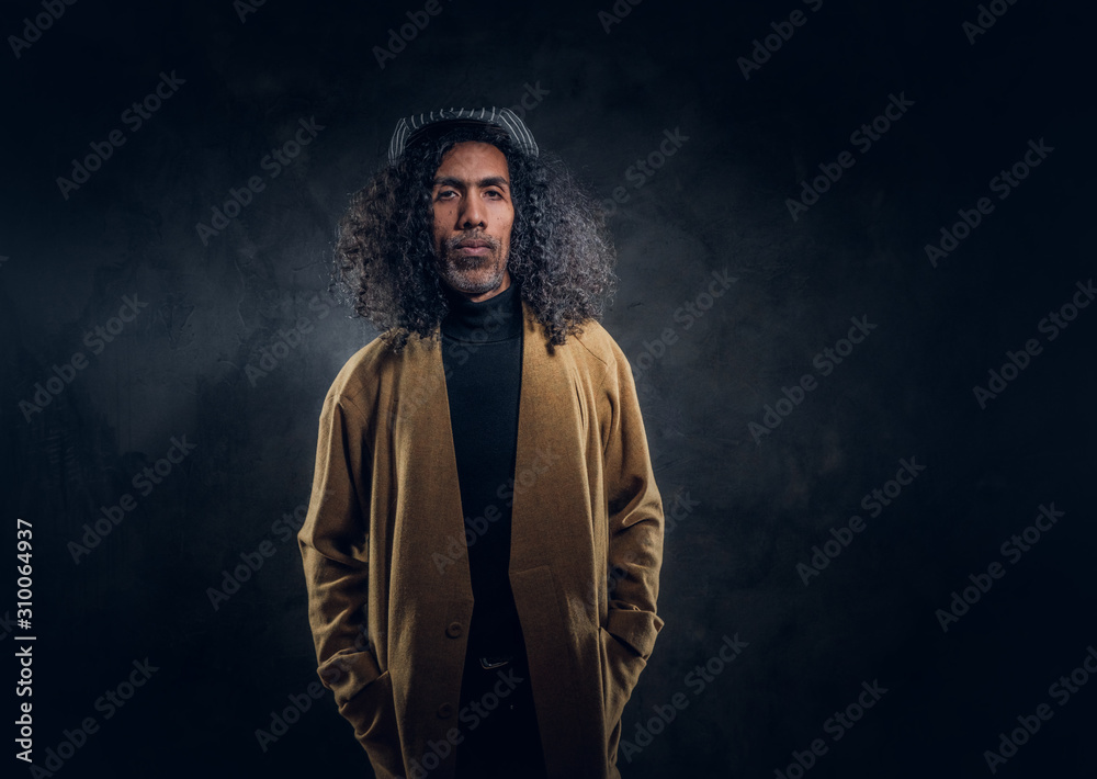 Portrait of middle aged charismatic man in brown coat at dark photo studio. Portrait of middle aged charismatic man in brown coat at dark photo studio.