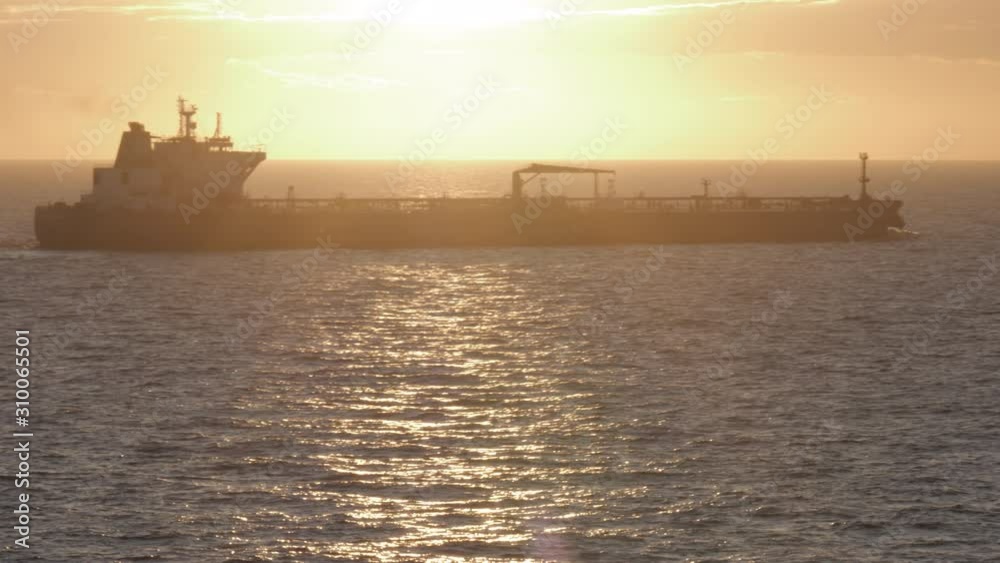 Tanker ship heading at sea in sun back light Tanker ship heading at sea in sun back light