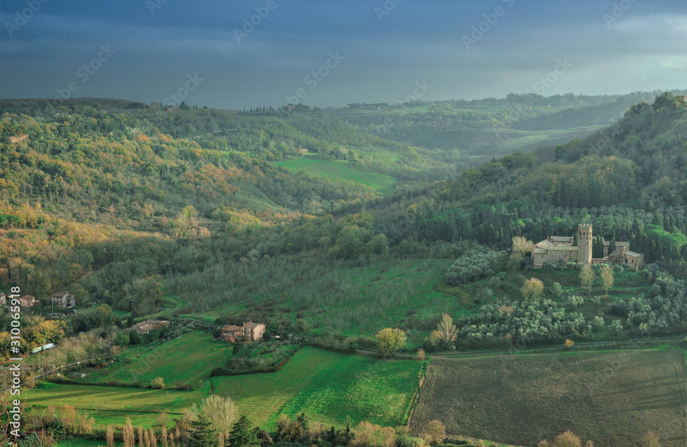 Cultivated fields, hills in the fog. Evening landscape, Italy. 