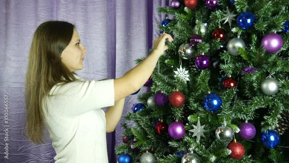 Beautiful young girl dresses up the Christmas tree close up cute Beautiful young girl dresses up the Christmas tree close up cute