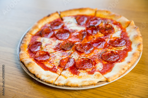 round pizza with sausage, cheese and spices