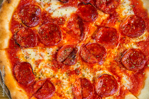round pizza with sausage, cheese and spices