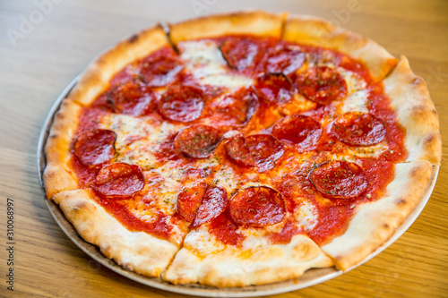 round pizza with sausage, cheese and spices