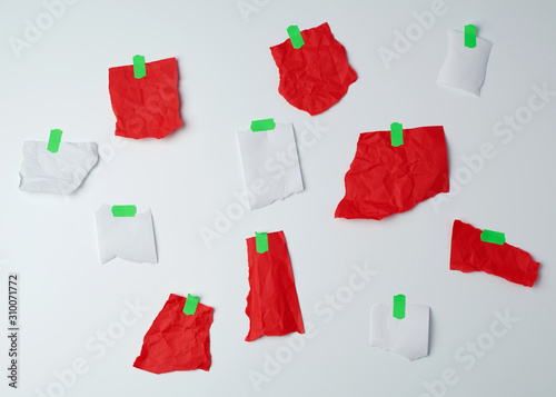 lot of torn red and white pieces of paper glued with green scotch tape