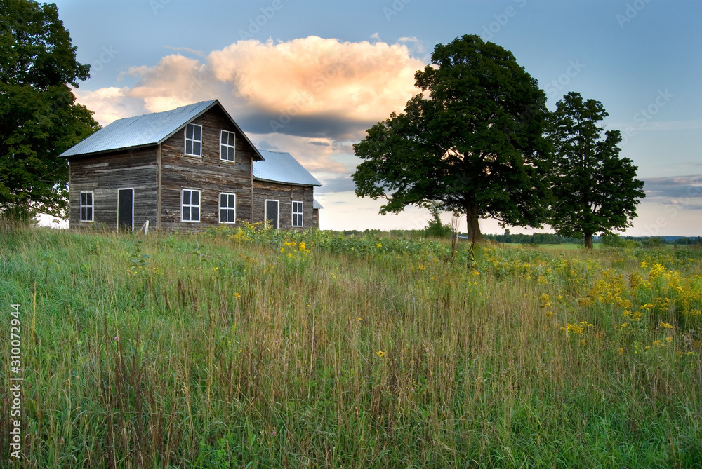 Obraz premium Abanboned Farm House with Beautiful Clouds in Rural Canada