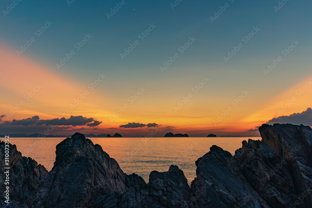 Spectacular sunset over rocks on the beach Spectacular sunset over rocks on the beach
