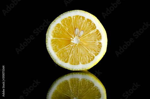 Close up view of lemon piece isolated on black.