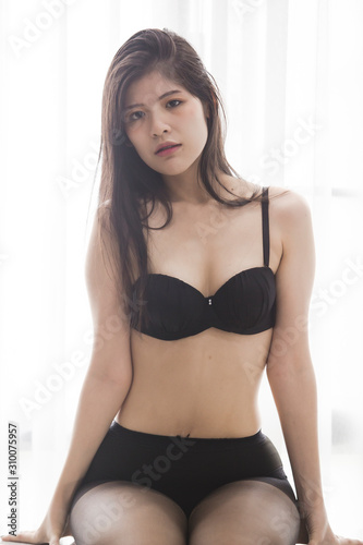 Sexy women wearing black lingerie doing various poses by the window of light © chaiviewfinder