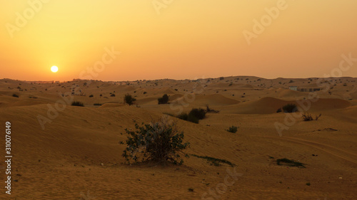 sunset in a desert, orange sun and red sand