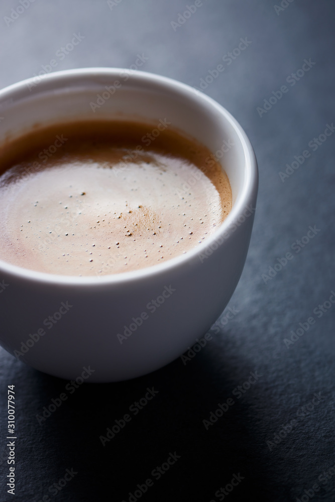 Cup of coffee on dark stone background. Close up. Cup of coffee on dark stone background. Close up.