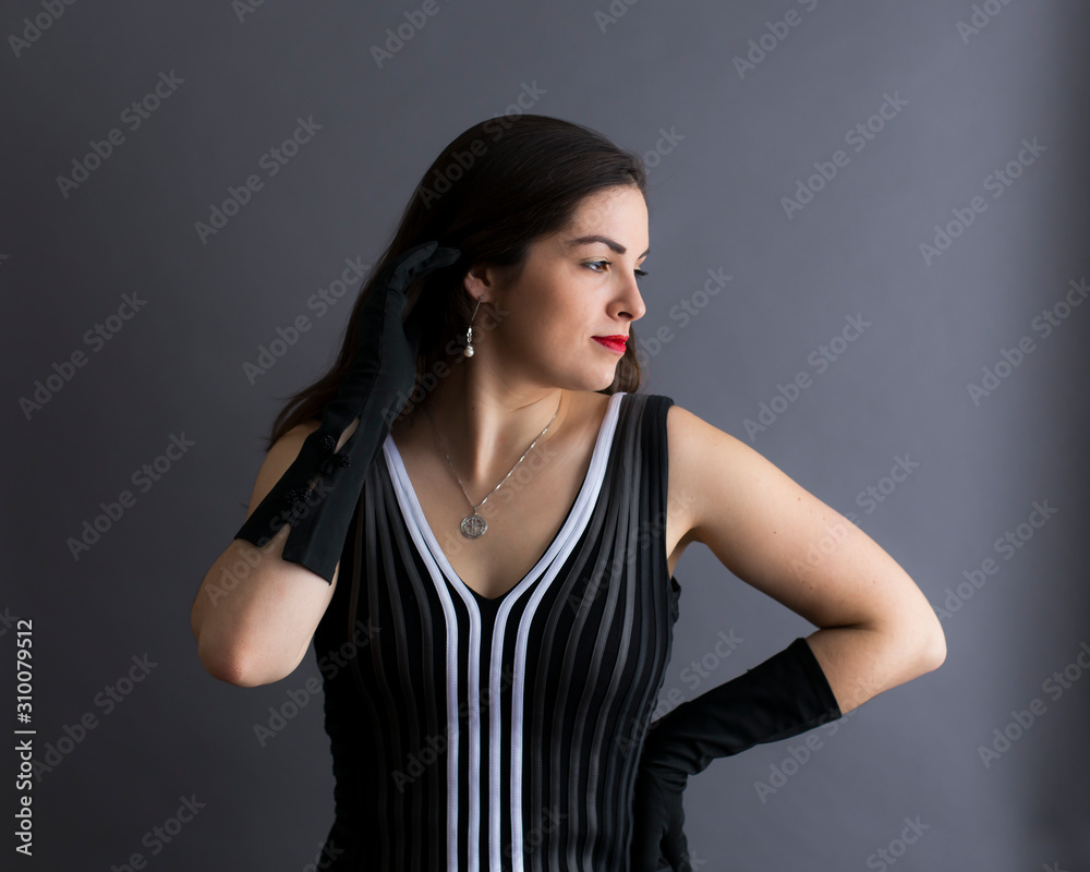 Medium profile portrait of beautiful young brunette in graphic sleeveless black and white top and long evening gloves Medium profile portrait of beautiful young brunette in graphic sleeveless black and white top and long evening gloves