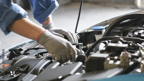 Asian Man mechanic inspection writing note on clipboard.Blue car for service maintenance insurance with car engine.for transport automobile automotive 