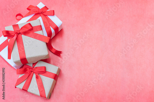 Top view close up three gift boxes. Red ribbon bow with gift boxes on red background, Wrapped vintage box with copy space