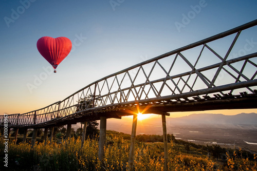 Red hot air balloon in the shape of a heart over the  sunset at Ban Doi Sa-ngo Chiangsaen, Chiang Rai Province, Thailand.