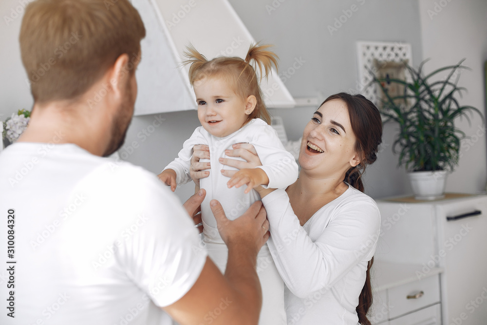 Cute little daughter in a white sweater. Family at home in a kitchen. pregnant woman. Cute little daughter in a white sweater. Family at home in a kitchen. pregnant woman.