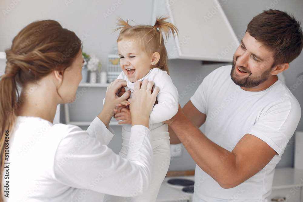 Cute little daughter in a white sweater. Family at home in a kitchen. pregnant woman. Cute little daughter in a white sweater. Family at home in a kitchen. pregnant woman.