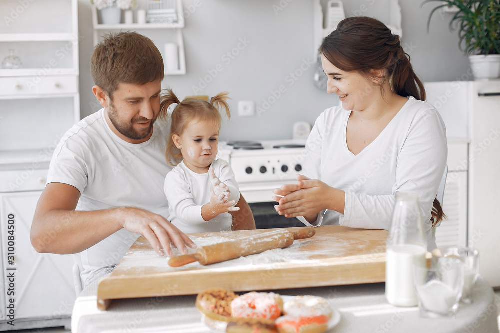Family in a kitchen. Beautiful mother with little daughter. Family at home Family in a kitchen. Beautiful mother with little daughter. Family at home