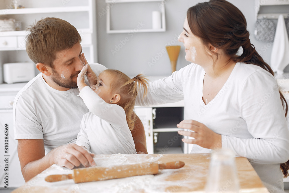 Family in a kitchen. Beautiful mother with little daughter. Family at home Family in a kitchen. Beautiful mother with little daughter. Family at home