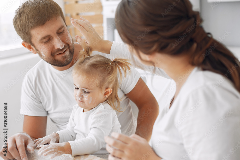 Family in a kitchen. Beautiful mother with little daughter. Family at home Family in a kitchen. Beautiful mother with little daughter. Family at home