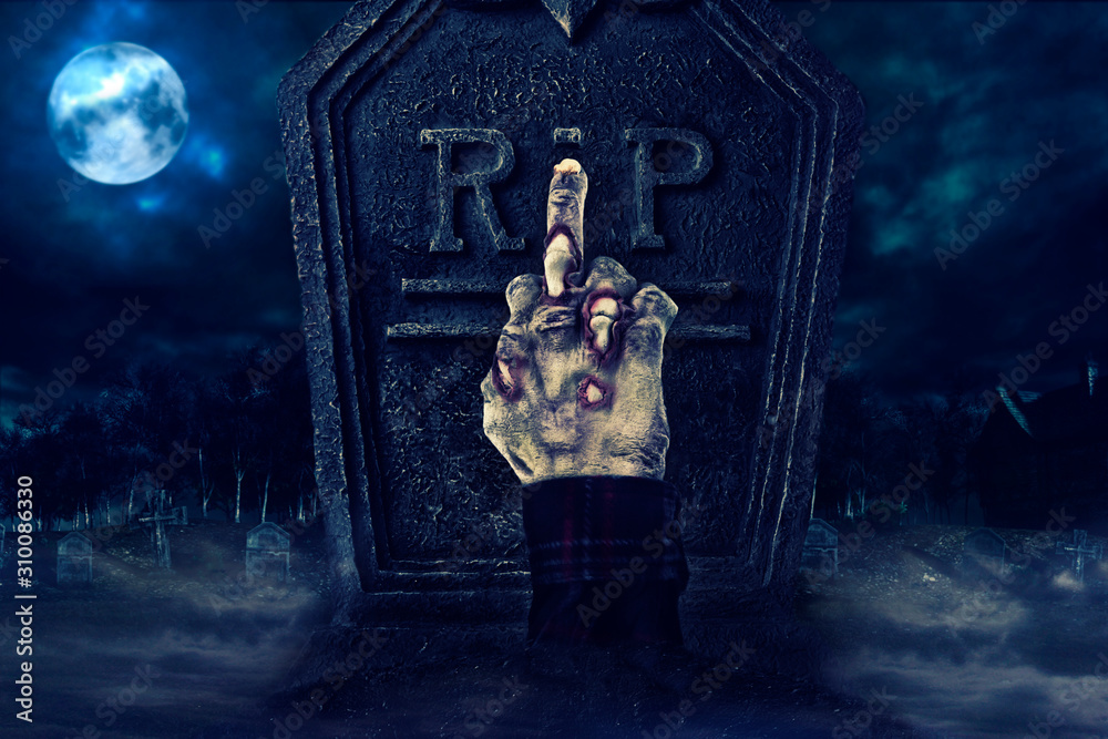 Zombie hand showing middle finger in front of tombstone, creepy cemetary in the background. Zombie hand showing middle finger in front of tombstone, creepy cemetary in the background.