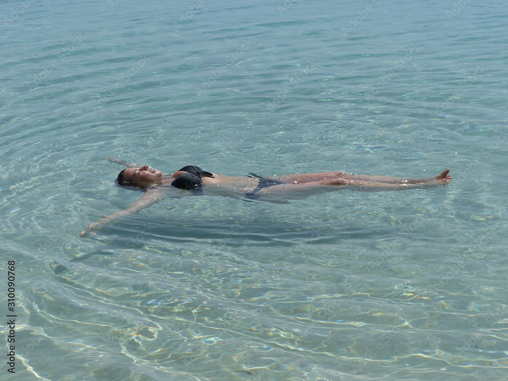 woman lying in a crystal blue water