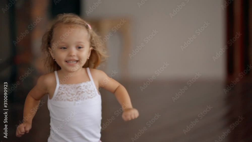 happy little girl running through house with stylish modern interior in slow motion. kid in pajamas running towards mother's hands. concept of carefree childhood. lifestyle time spending of a child happy little girl running through house with stylish modern interior in slow motion. kid in pajamas running towards mother's hands. concept of carefree childhood. lifestyle time spending of a child