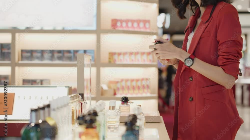 Woman talks with the perfumer at a department store as she shiff, smells, tests a new fragrance