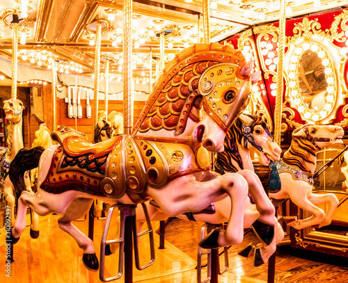 Fotografie Classic Carousel merry go round wlth three horses lined up, Bright and Colorful